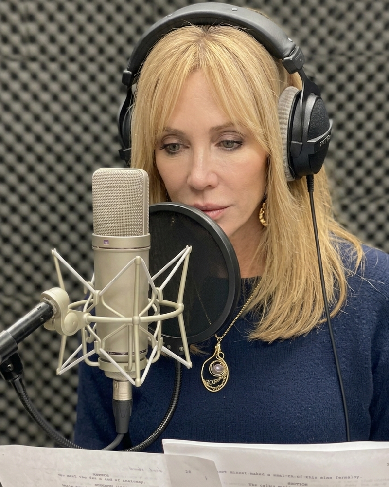 Jenn Wylde recording in the voiceover booth with a studio mic and headphones